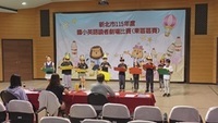 10位四年級學生在舞台上排排站，演出英語讀者劇場的戲碼，他們的前方有三位評審