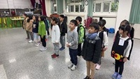 一、二年級學生共16人在小禮堂排排站練習英語歌唱